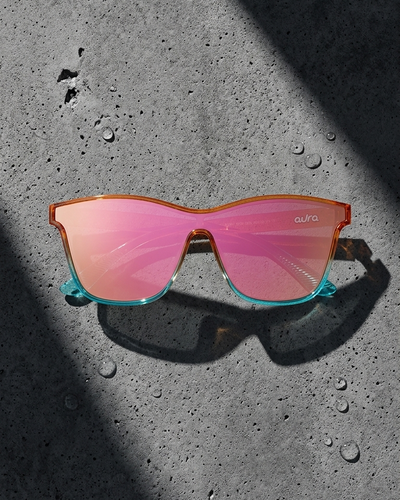 Sunglasses with red lenses and orange colorful frame on a textured black surface